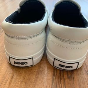 Low-top leather slip-on sneakers in white.